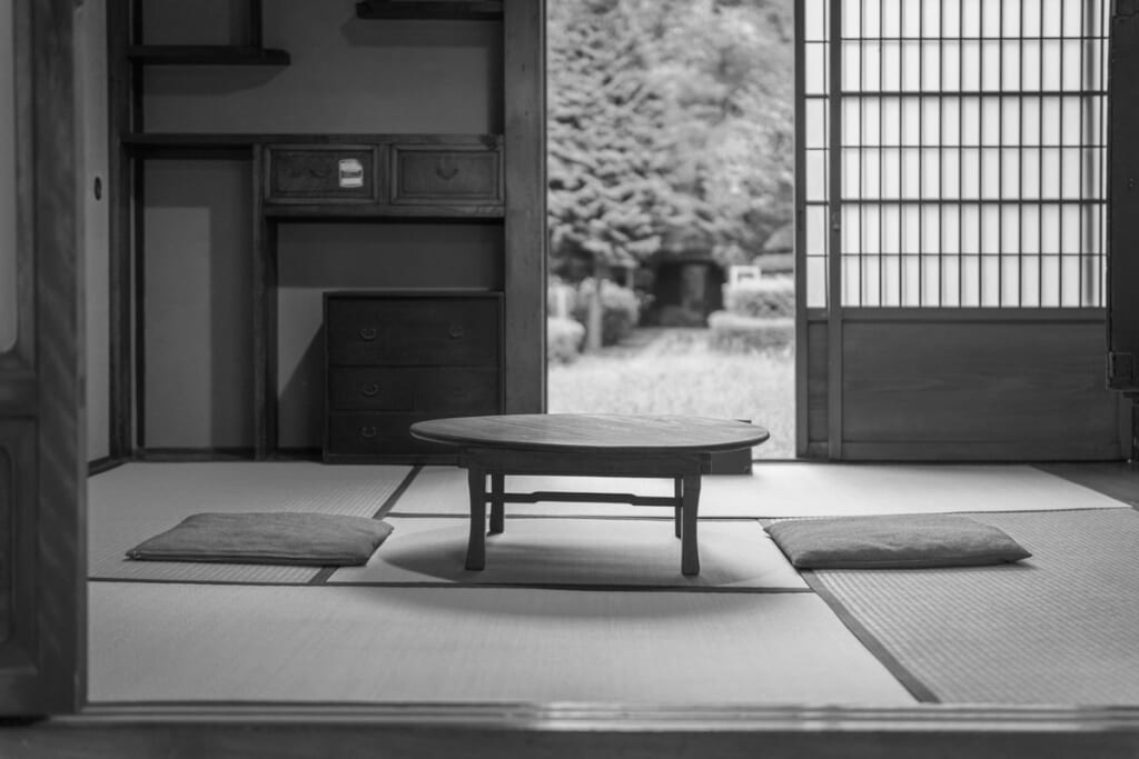 ちゃぶ台と座布団が置かれた古い日本家屋の和室